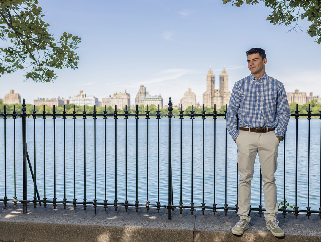 Benjamin Barkoff standing by a fence alongside a river.