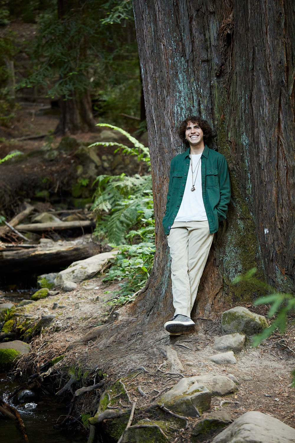 Julian Berkowitz-Sklar smiles while leaning against a tree.