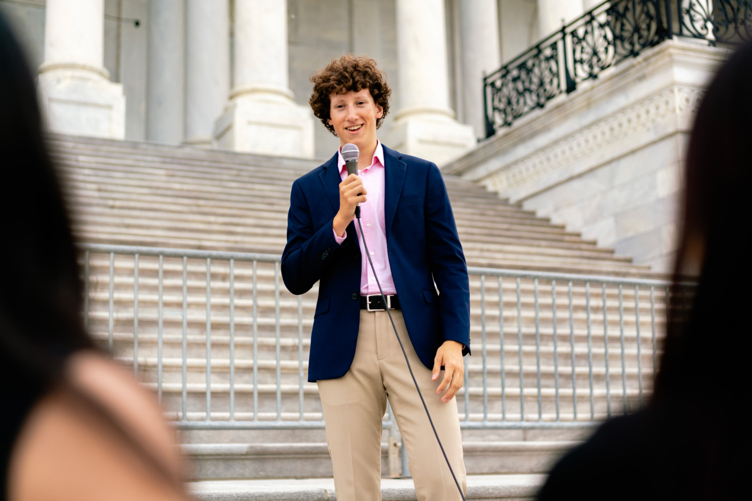 Max Bernsten speaking into a microphone to an audience outside the U.S. Capitol