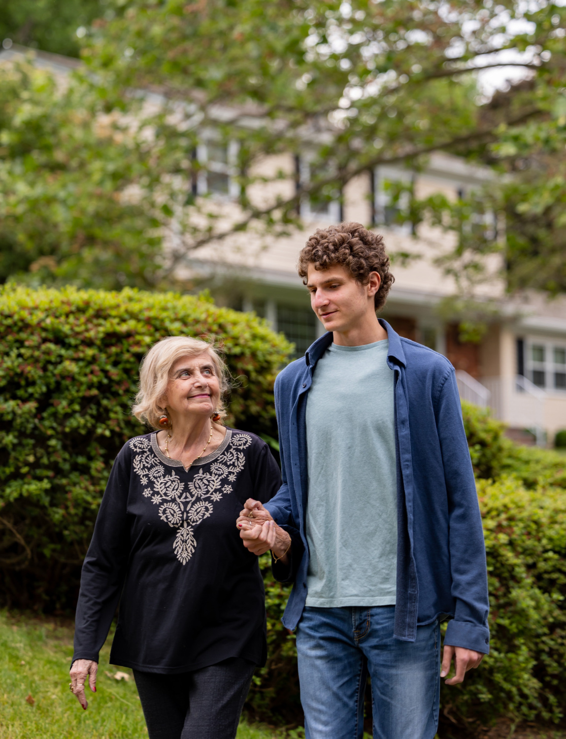 Aron Goodman walking outside with his grandmother Tova Friedman.