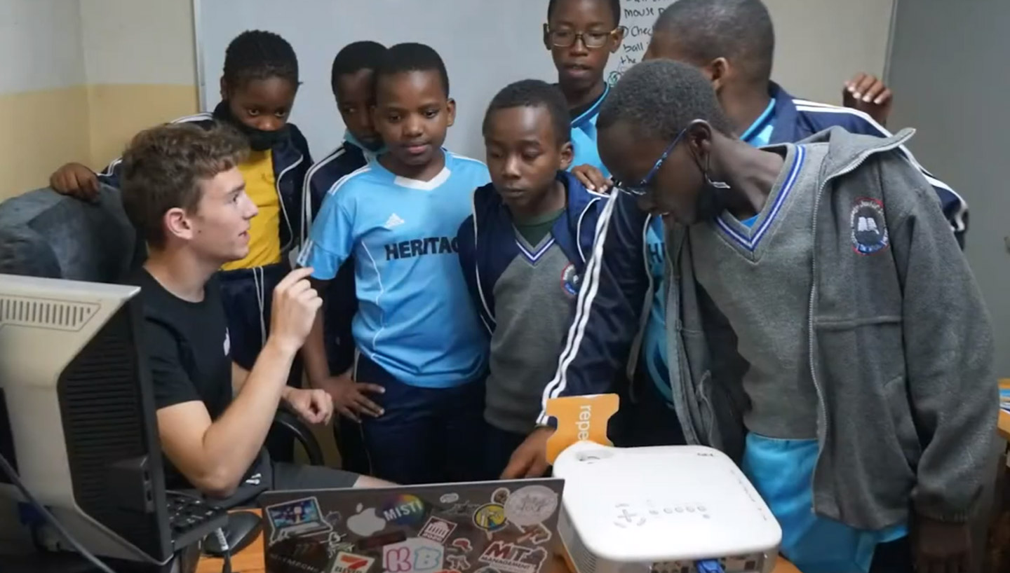 Robbie teaching a group of young boys about computers.