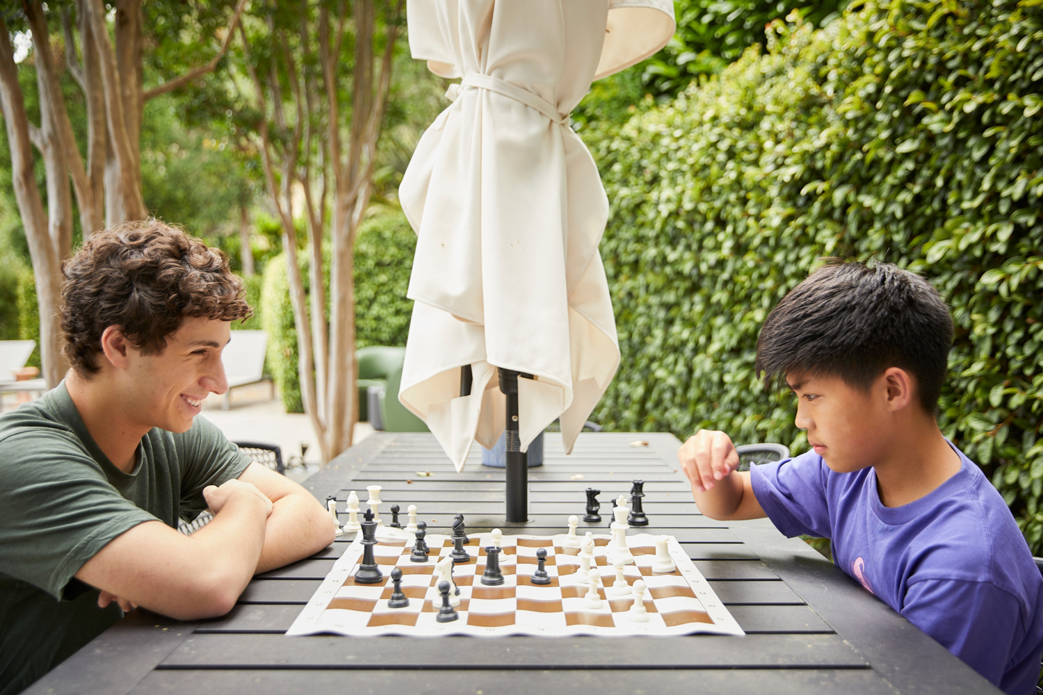 Henry Lien plays chess with a young boy.