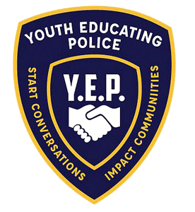 The logo is a dark blue shield outlined in gold. In the center is 2 hands shaking with the letter Y E P above it. Around the center part are the words Youth Educating Police Start Conversations Impact Communities.