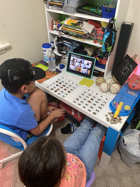 Two elementary students watching a lesson on a tablet.