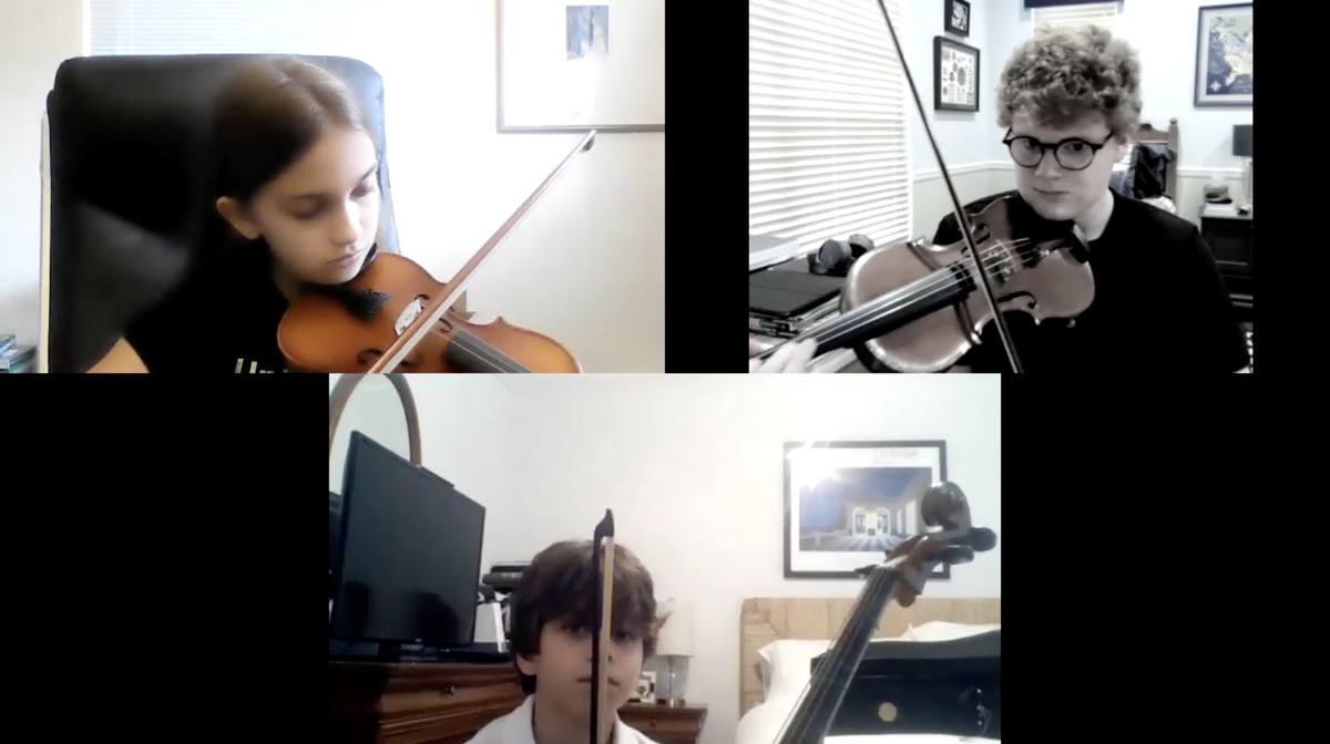 Screenshot of 3 kids playing violins.